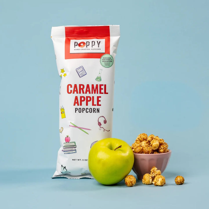 Poppy Caramel Apple Popcorn displayed with a fresh green apple and a bowl of golden caramel-coated popcorn.