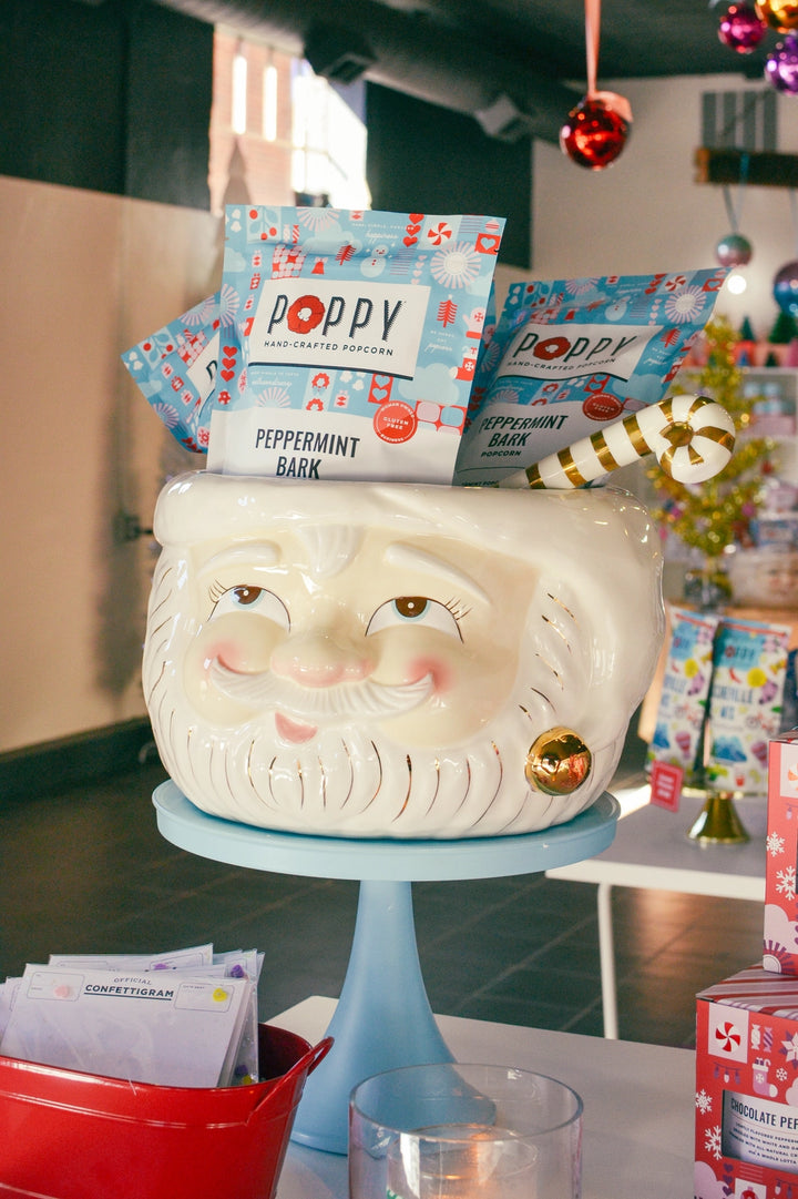 Poppy Peppermint Bark Popcorn bags displayed in a festive Santa serving bowl