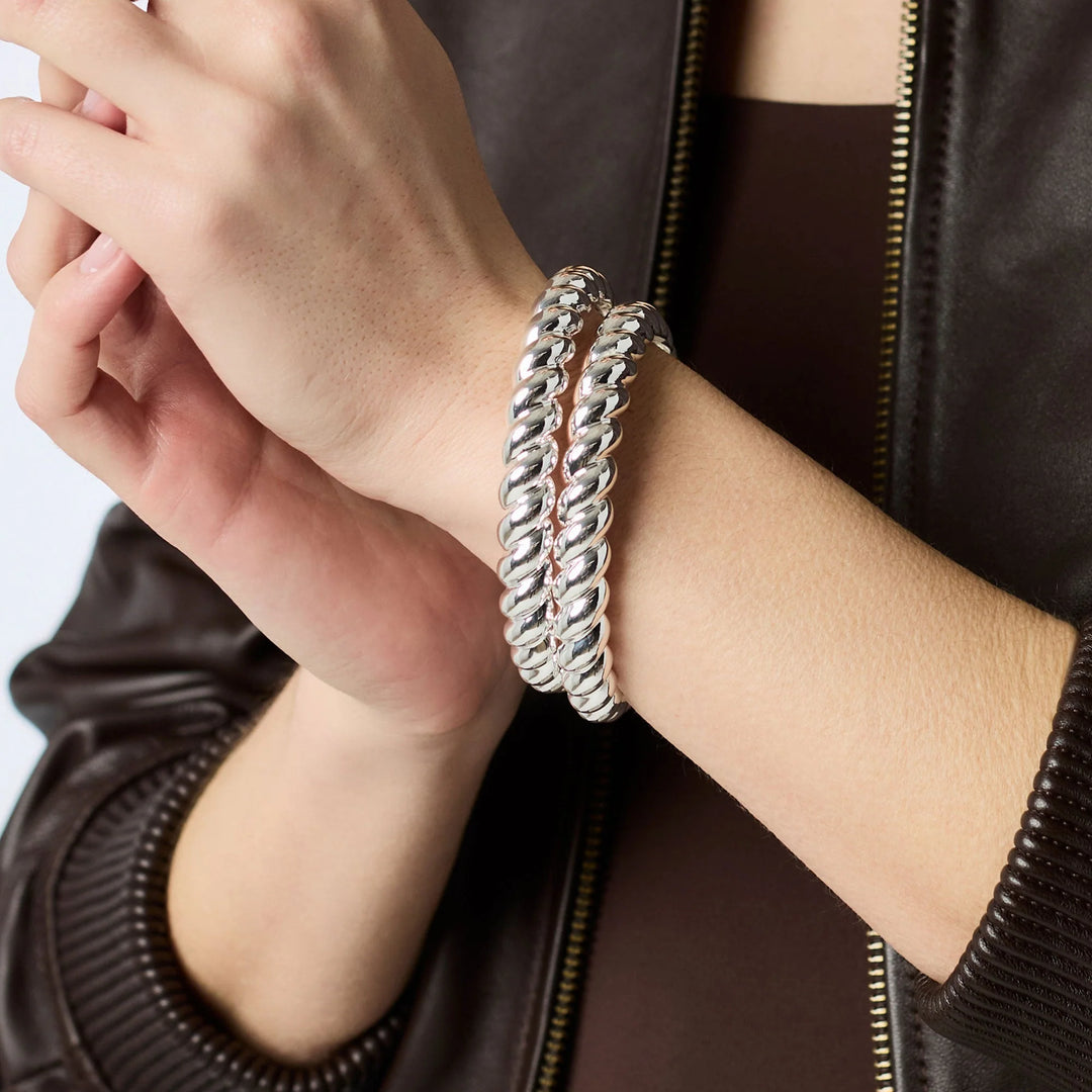 Model wearing stacked silver Ravello Bangle bracelets