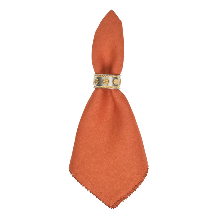 Rust terracotta linen napkin styled with a gold decorative napkin ring for an elegant table setting