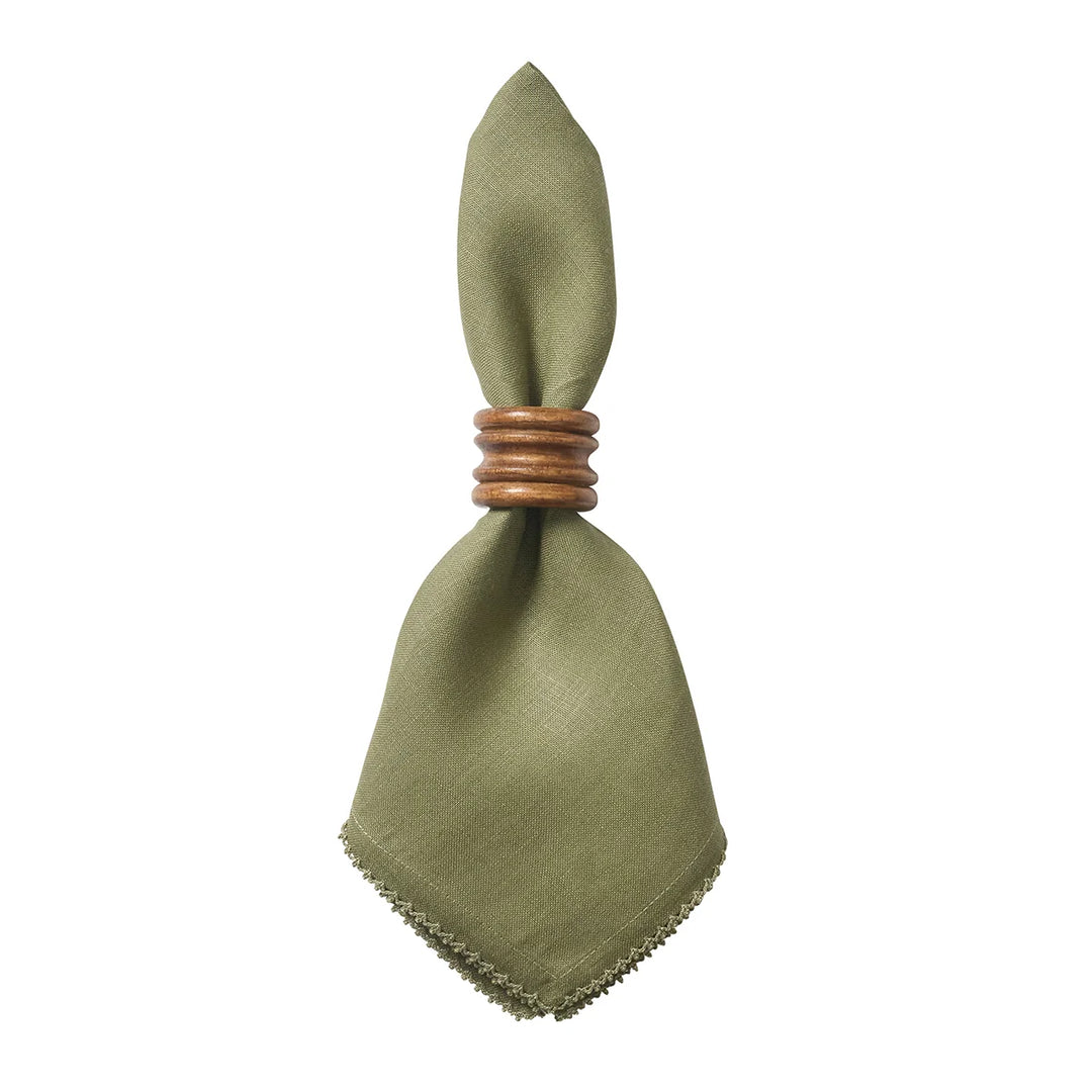 Sage green linen dinner napkin with crochet edge styled with a warm wood napkin ring