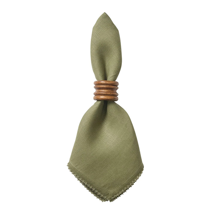 Sage green linen dinner napkin with crochet edge styled with a warm wood napkin ring