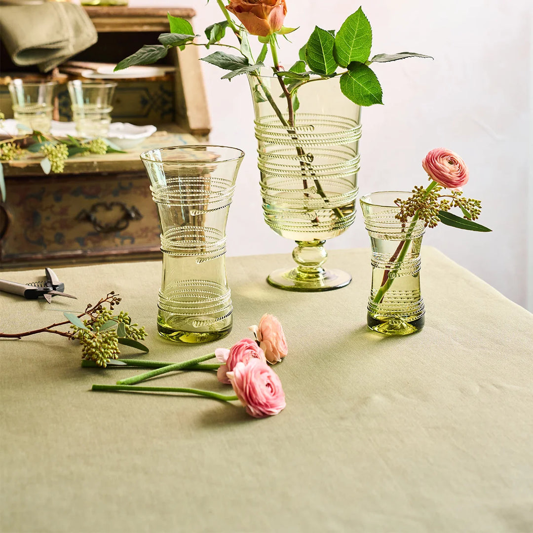 Sage green linen tablecloth styled with green glass vases and pink flowers for an elegant spring or fall tablescape