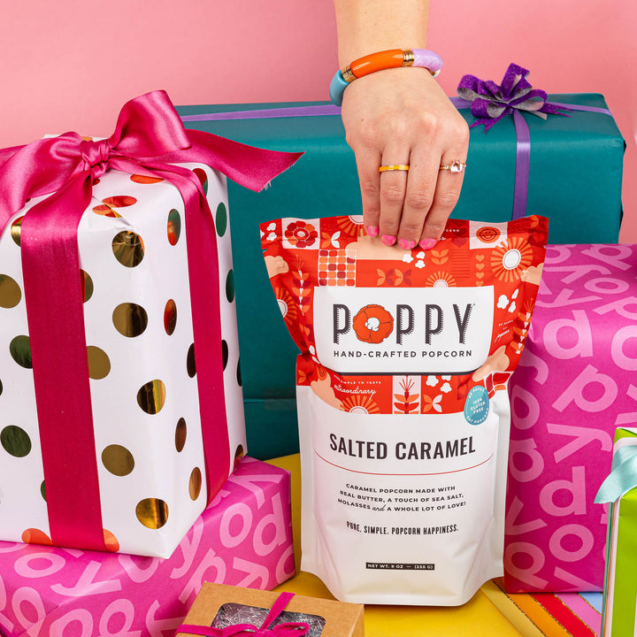 Poppy Salted Caramel Hand-Crafted Popcorn displayed with colorful wrapped gifts