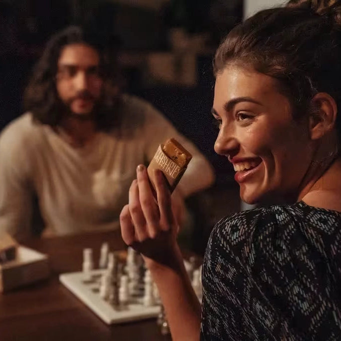Stars + Honey Cacao Salt Caramel Peanut collagen protein bar lifestyle image with chess board