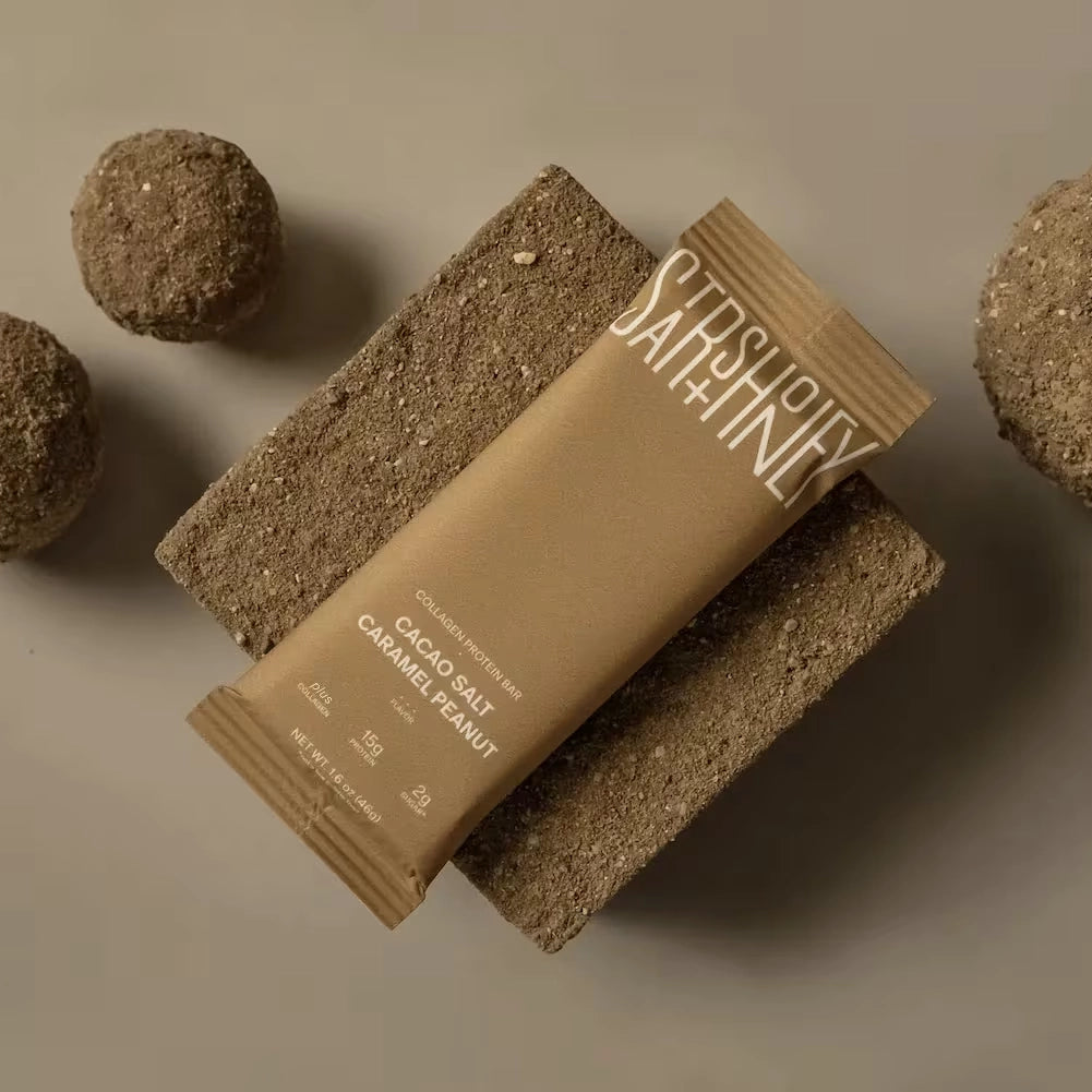 Stars + Honey Cacao Salt Caramel Peanut collagen protein bar product on stone lifestyle