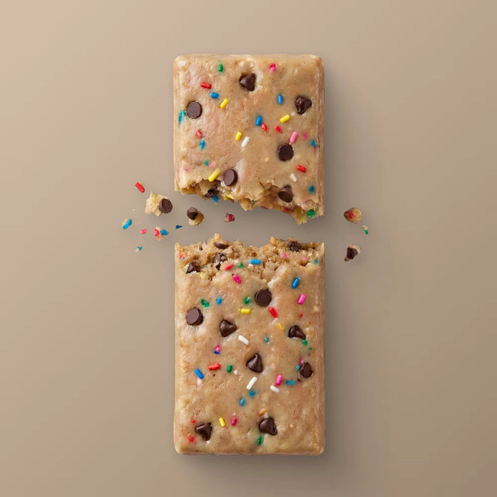 Close-up of Stars + Honey Cake &amp; Ice Cream collagen protein bar texture with chocolate pieces and rainbow sprinkles