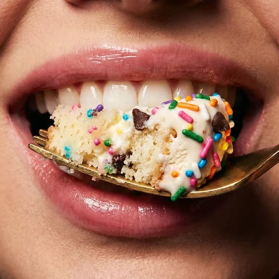 Stars + Honey Cake &amp; Ice Cream collagen protein bar pieces with ice cream and rainbow sprinkles on a spoon