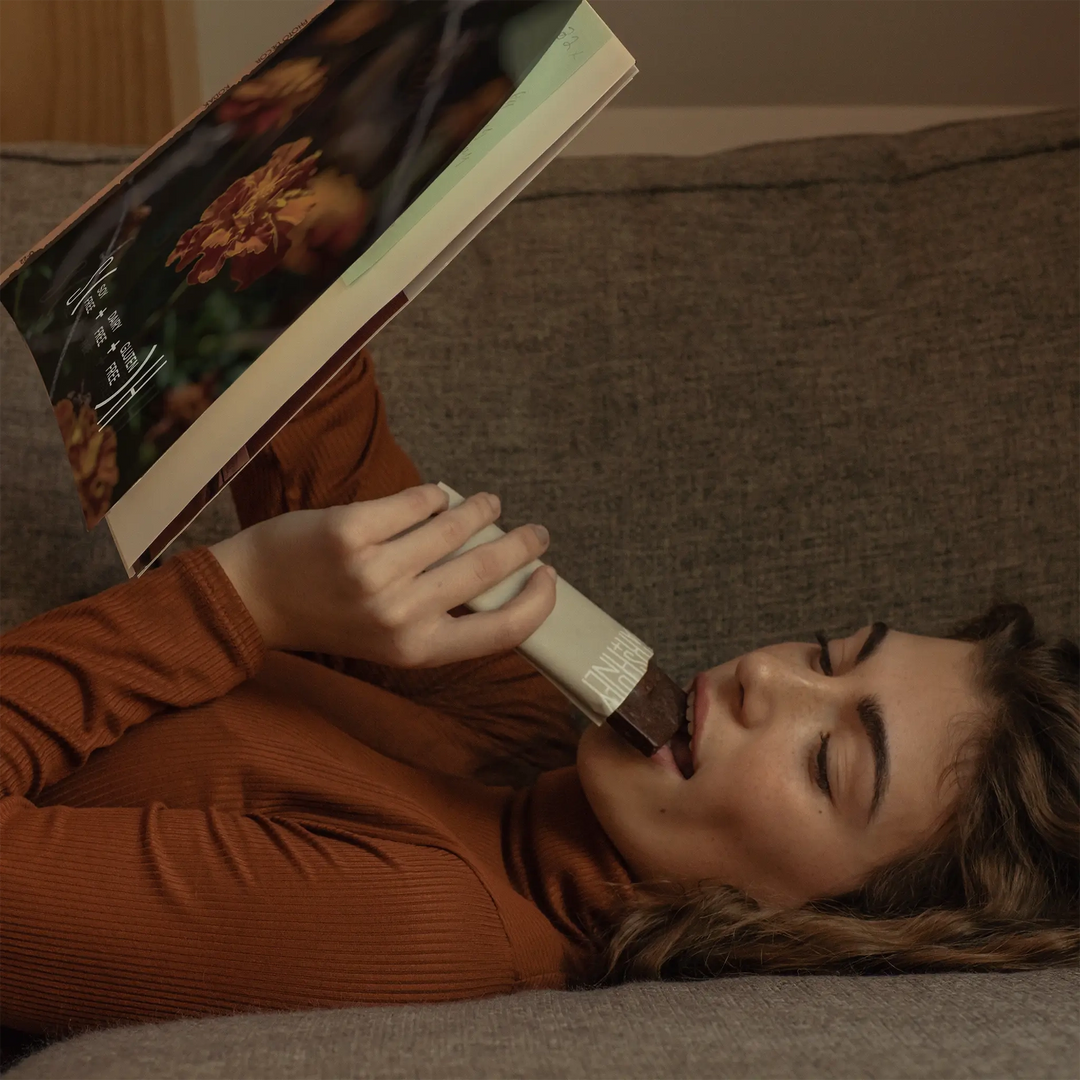 Woman holding a Stars + Honey Dark Chocolate Coconut collagen protein bar