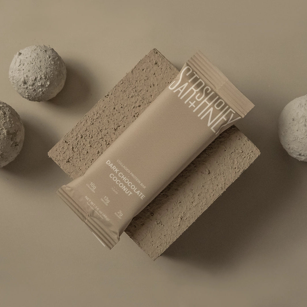 Stars + Honey Dark Chocolate Coconut collagen protein bar styled on a neutral background