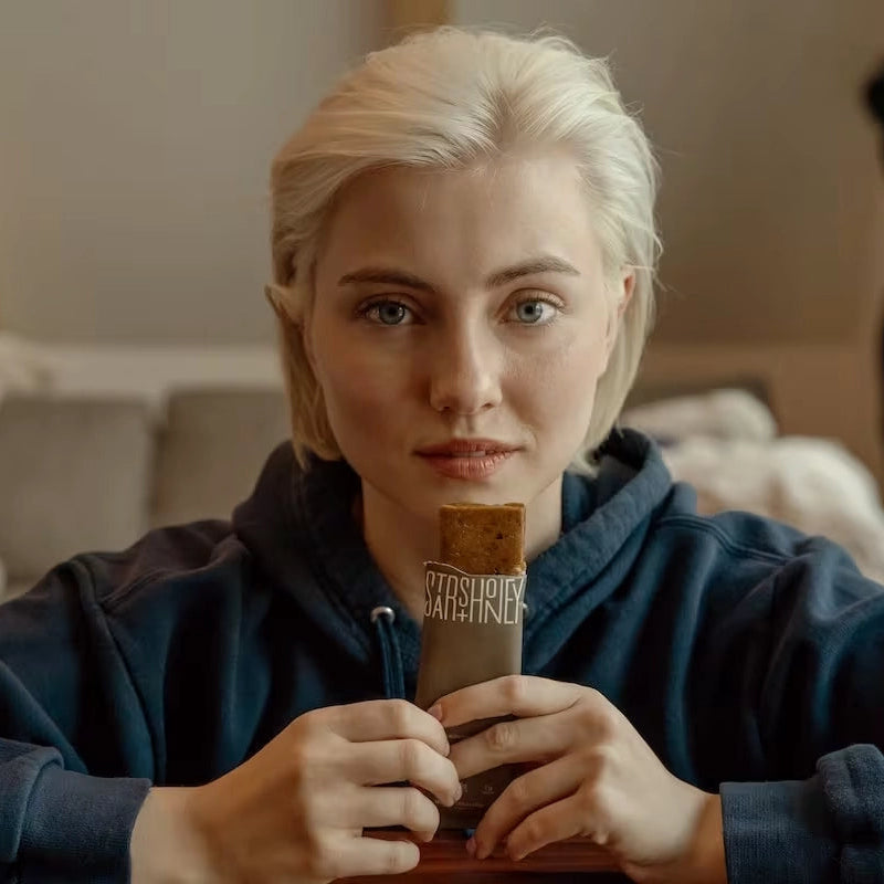 Woman enjoying coffee with a Stars + Honey Espresso Vanilla Cinnamon collagen protein bar