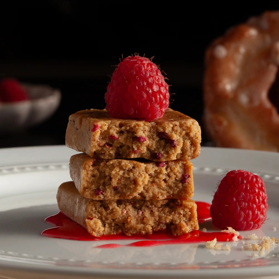 Stars + Honey Raspberry Donut protein bars styled with fresh raspberries and glazed donut