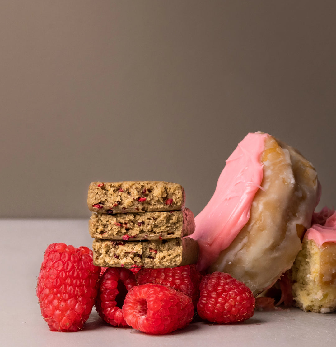 Stars + Honey Raspberry Donut protein bars styled with fresh raspberries and pink glazed donut