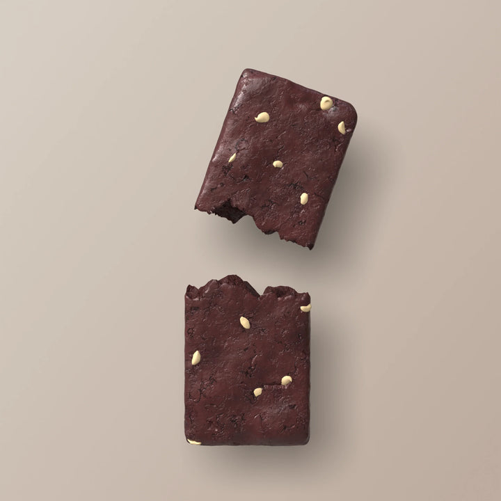 Close-up of Stars + Honey Red Velvet collagen protein bar pieces with creamy white chips
