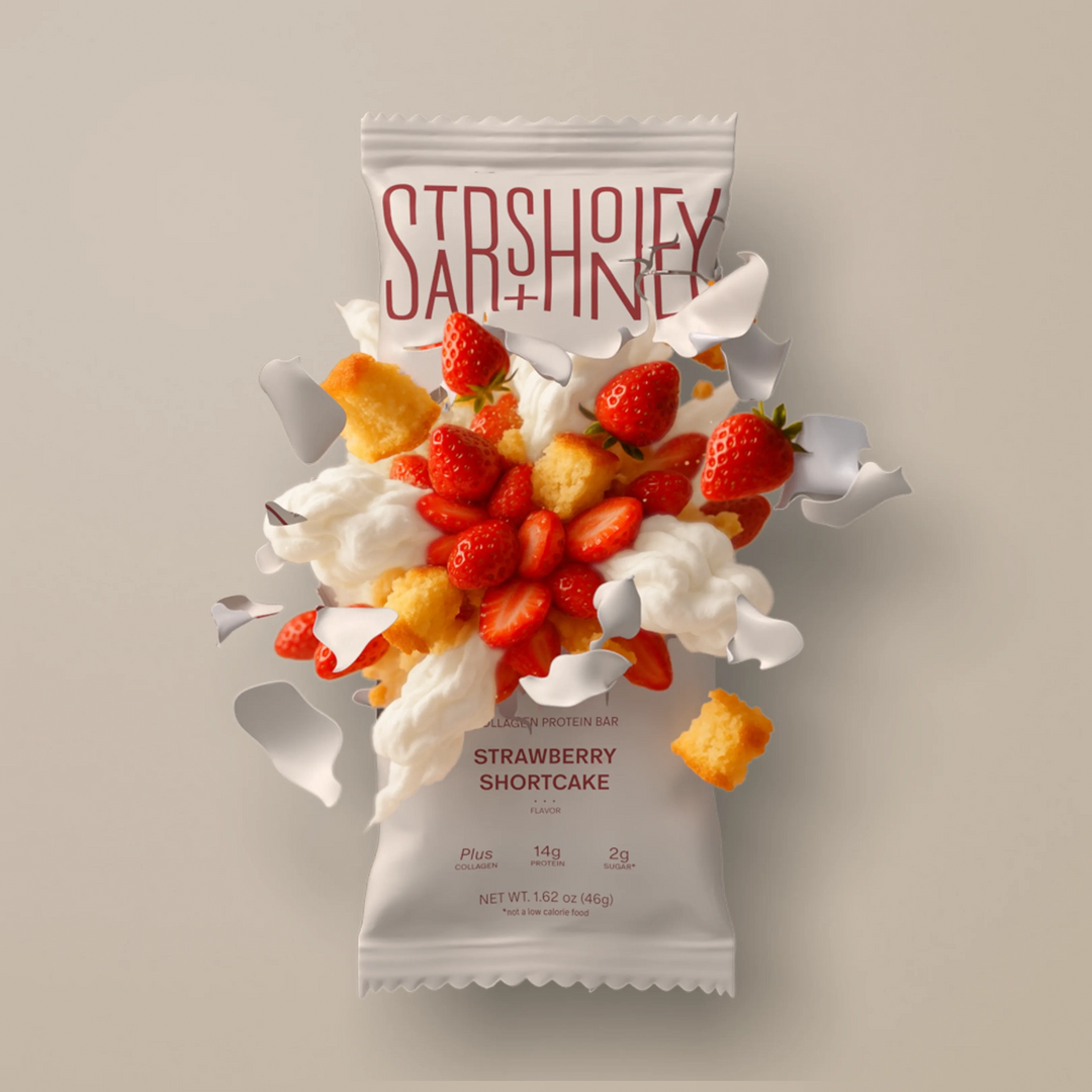 Stars + Honey Strawberry Shortcake protein bar styled with strawberries, cream and shortcake pieces