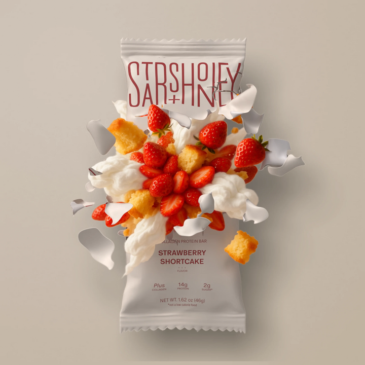 Stars + Honey Strawberry Shortcake protein bar styled with strawberries, cream and shortcake pieces
