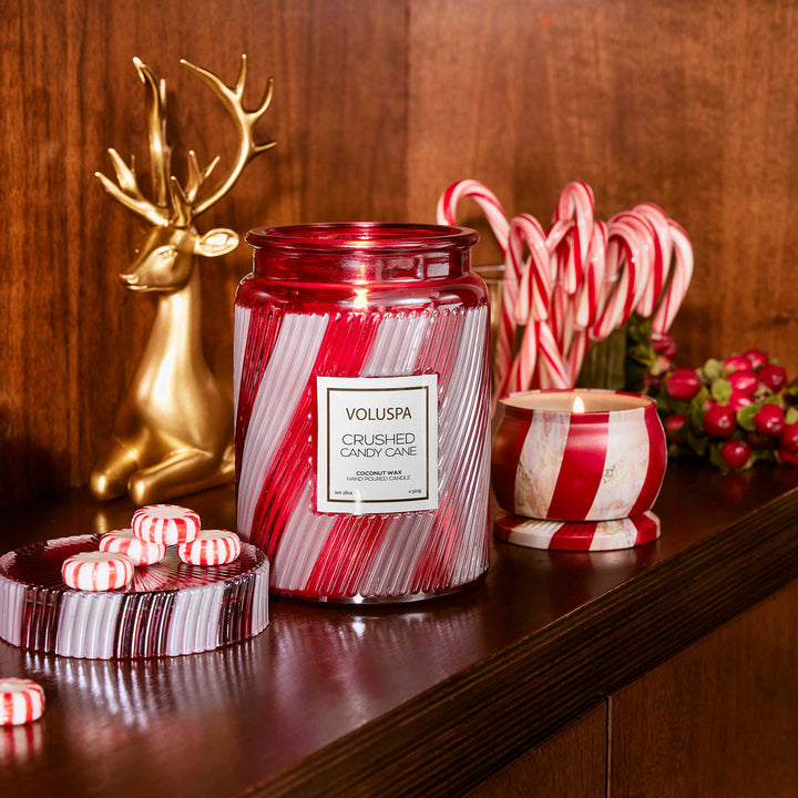 Voluspa Crushed Candy Cane Large Jar Candle displayed with candy canes and festive Christmas décor