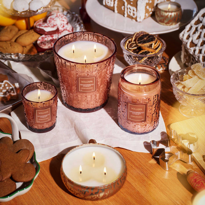 Gingerbread Chalet Classic Candle displayed with Voluspa holiday candles and festive gingerbread treats