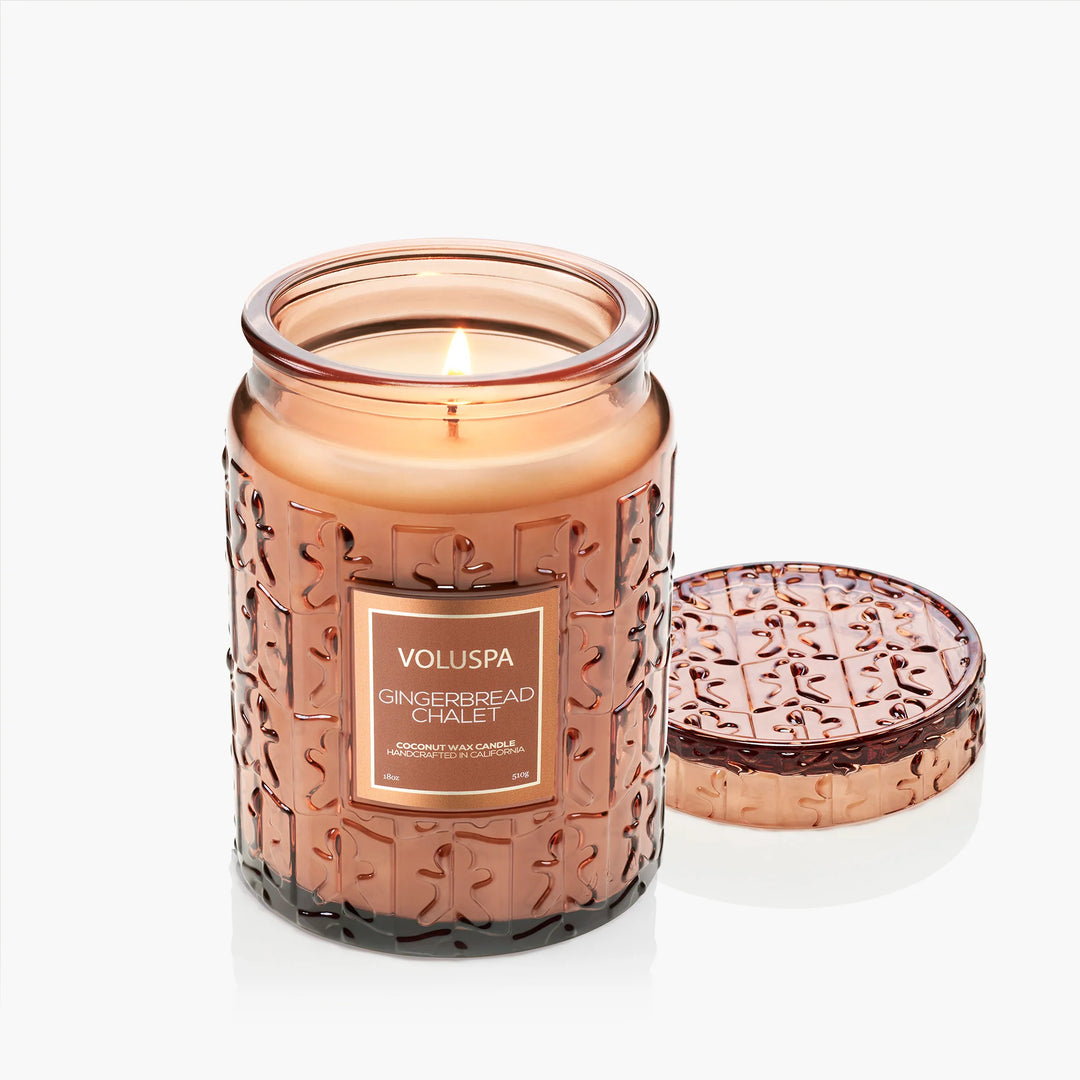 Lit Voluspa Gingerbread Chalet Large Jar Candle in embossed glass with decorative matching lid