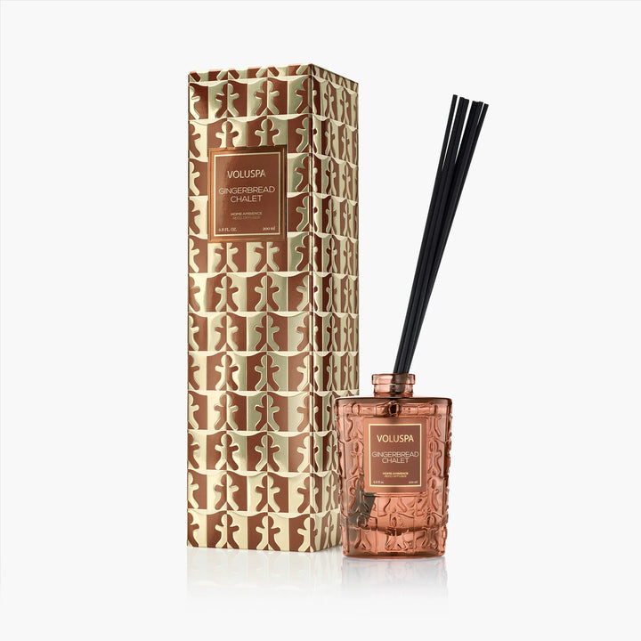 Voluspa Gingerbread Chalet Reed Diffuser with black reeds, amber embossed glass vessel and holiday gift box