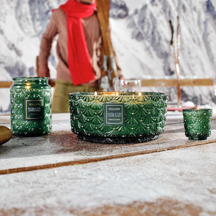 Noble Fir Garland Centerpiece Candle by Voluspa displayed with coordinating green holiday candles