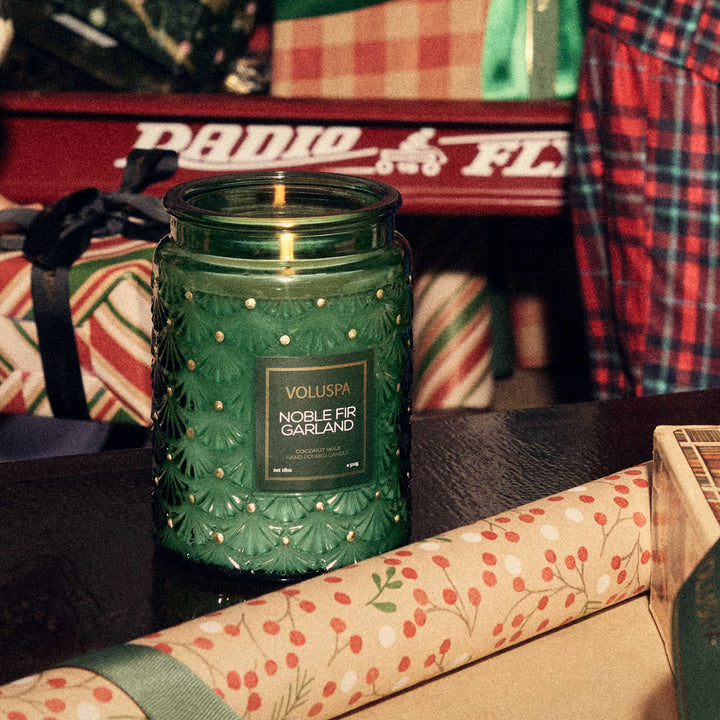 Voluspa Noble Fir Garland Large Jar Candle styled with festive Christmas gifts and holiday wrapping paper