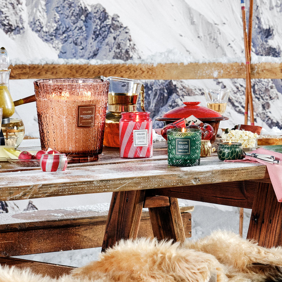Voluspa Noble Fir Garland Luxe Classic Candle styled with festive holiday candles in a winter ski lodge setting