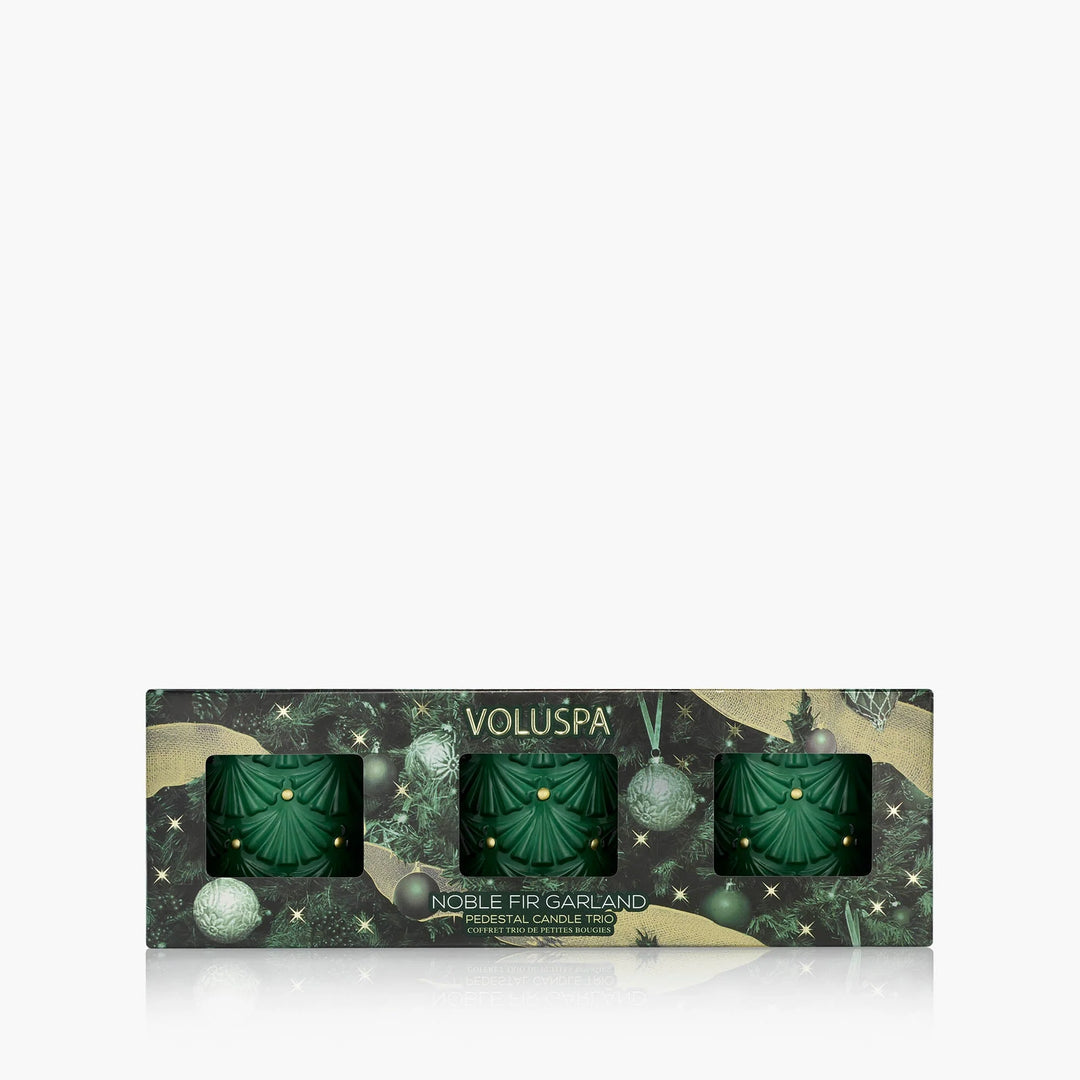 Voluspa Noble Fir Garland Mini Pedestal Trio Gift Set with three green holiday candles in festive gift packaging