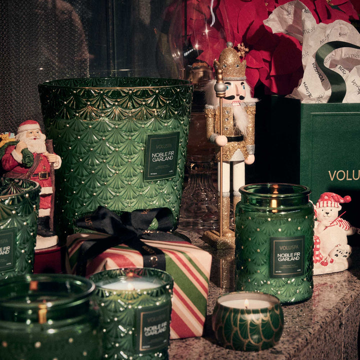 Voluspa Noble Fir Garland Mini Tin Candle displayed with Noble Fir Garland candles, Christmas gifts and nutcracker decor