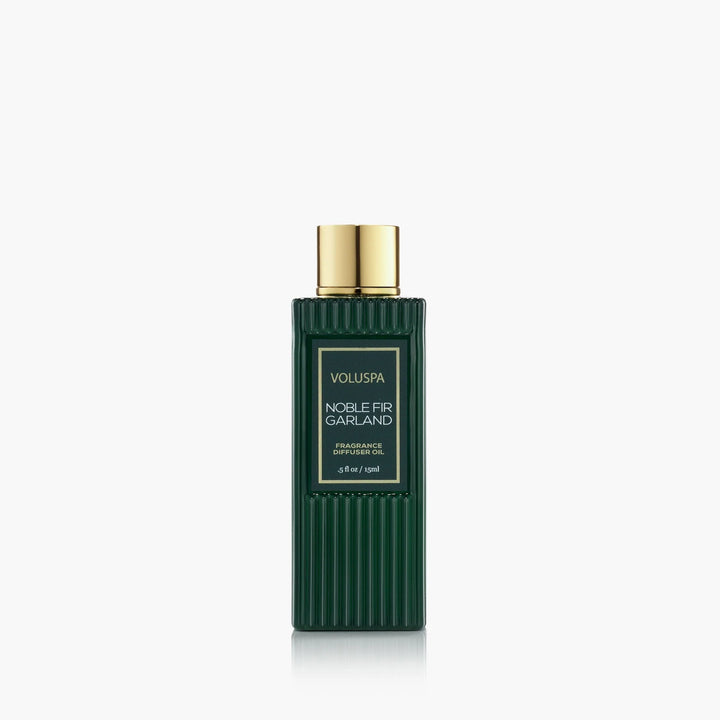 Voluspa Noble Fir Garland Ultrasonic Diffuser Fragrance Oil in a dark green bottle with gold cap