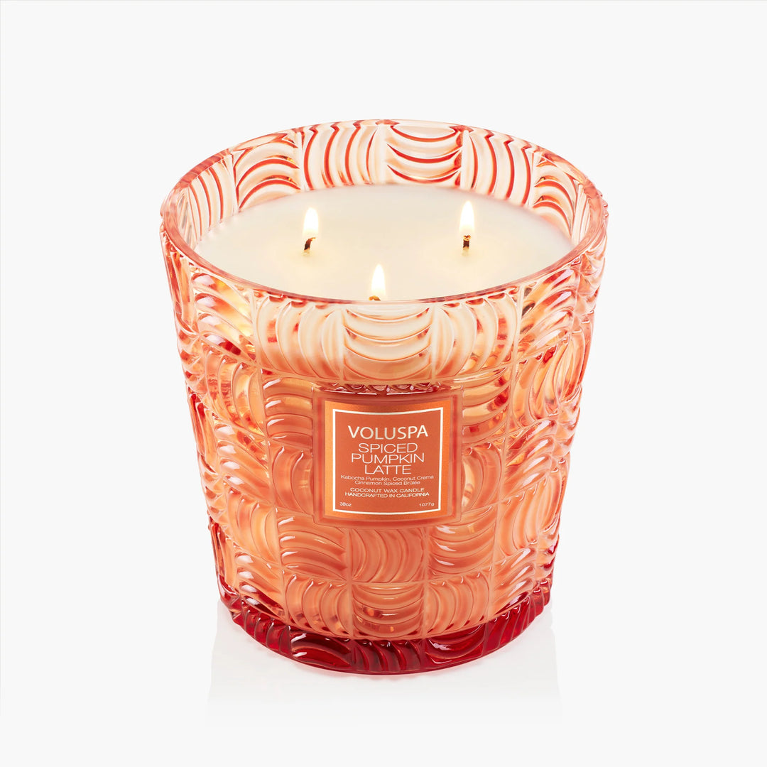 Lit Voluspa Spiced Pumpkin Latte 3 Wick Hearth Candle showing three wicks and embossed orange glass