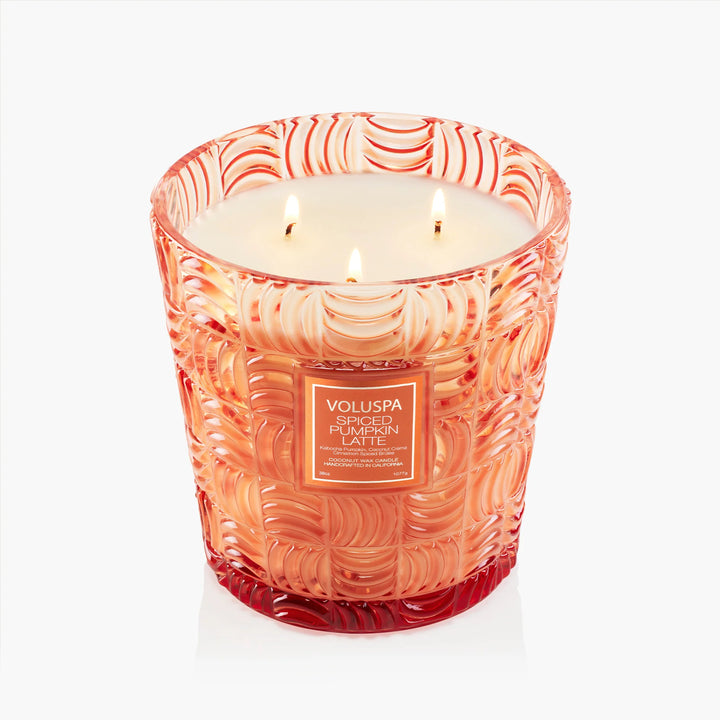 Lit Voluspa Spiced Pumpkin Latte 3 Wick Hearth Candle showing three wicks and embossed orange glass