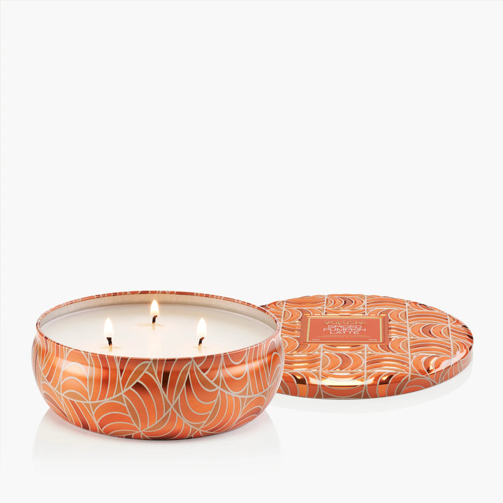 Open Voluspa Spiced Pumpkin Latte 3 Wick Tin Candle with three lit wicks and coordinating lid