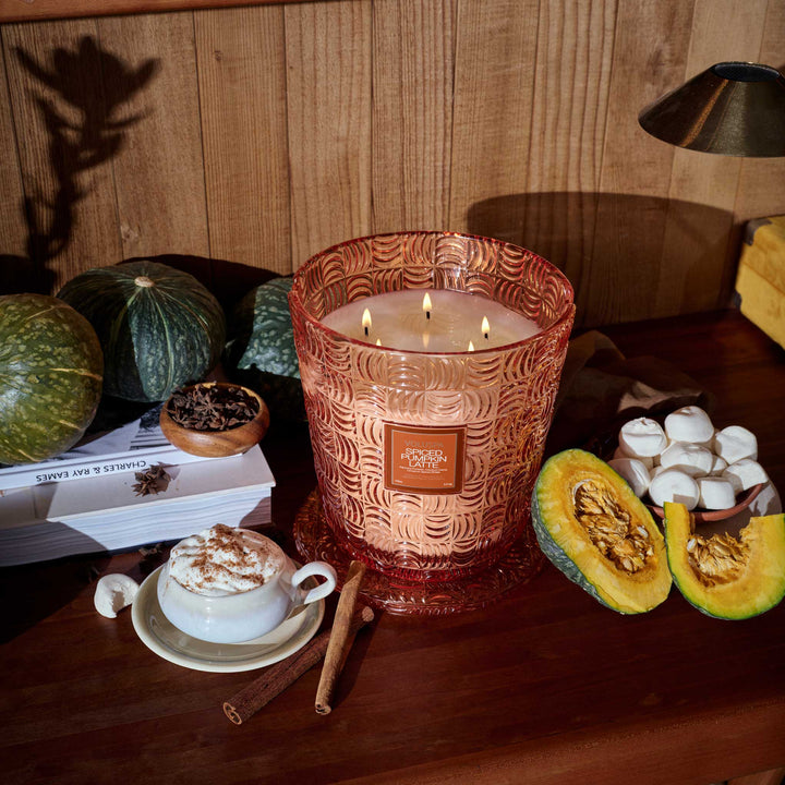 Voluspa Spiced Pumpkin Latte 5 Wick Hearth Candle styled with pumpkins, cinnamon sticks, and a pumpkin spice latte