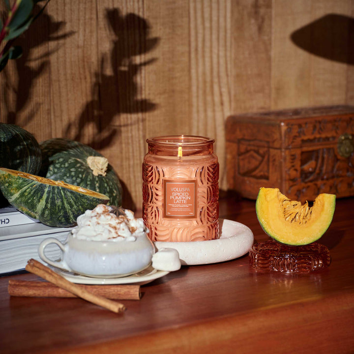 Voluspa Spiced Pumpkin Latte candle collection styled on a wooden coffee table for fall