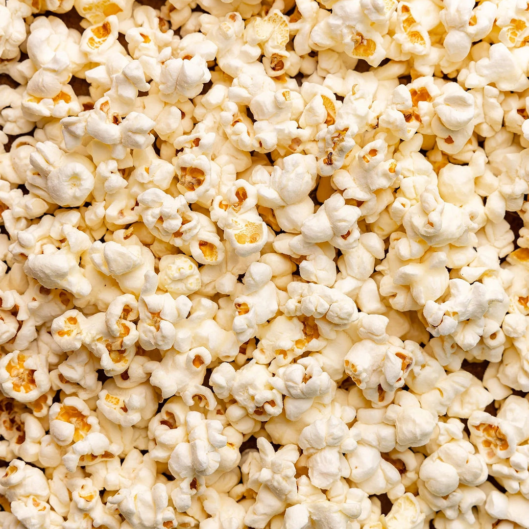 Close-up of White Cheddar Hand-Crafted Popcorn coated in creamy cheddar seasoning