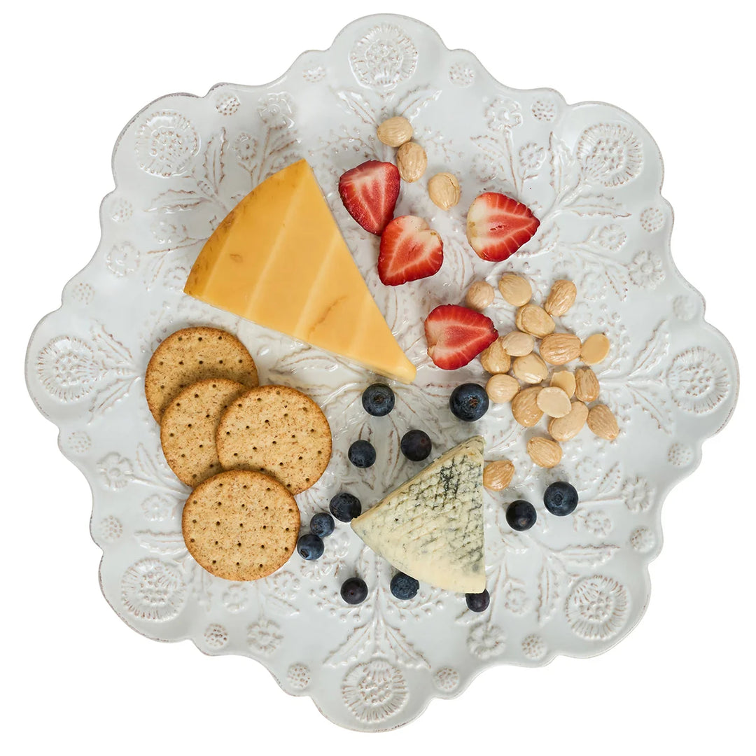 White floral round serving platter styled with cheese, crackers, strawberries, blueberries and almonds for entertaining.