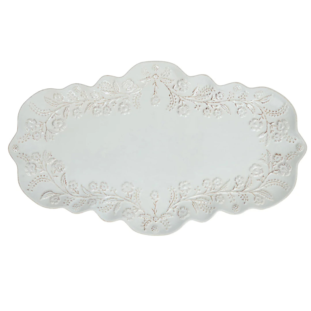White floral serving platter with raised botanical detailing and an elegant scalloped edge.