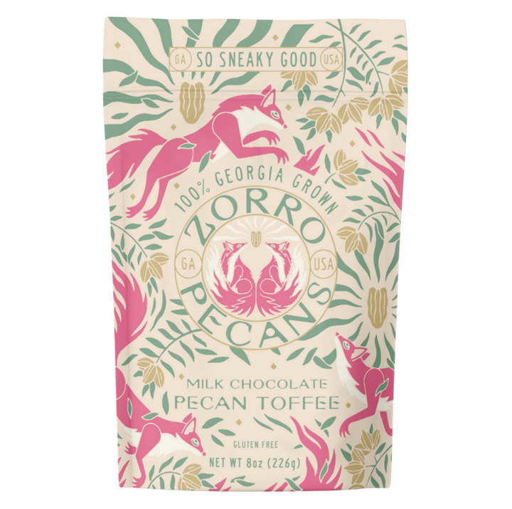 Zorro Milk Chocolate Pecan Toffee in decorative cream, pink, and green packaging featuring Georgia-grown pecans.