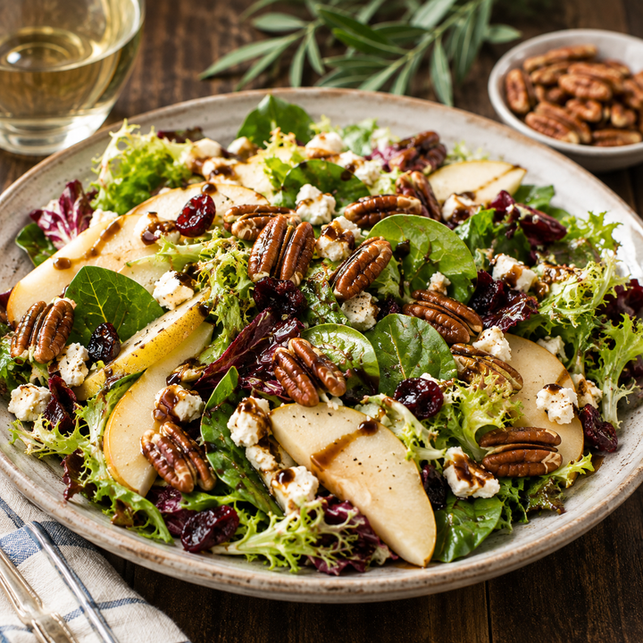 Zorro Pecans Roasted &amp; Lightly Salted premium Georgia pecans on a gourmet pear salad with mixed greens, goat cheese, dried cranberries, and balsamic glaze.